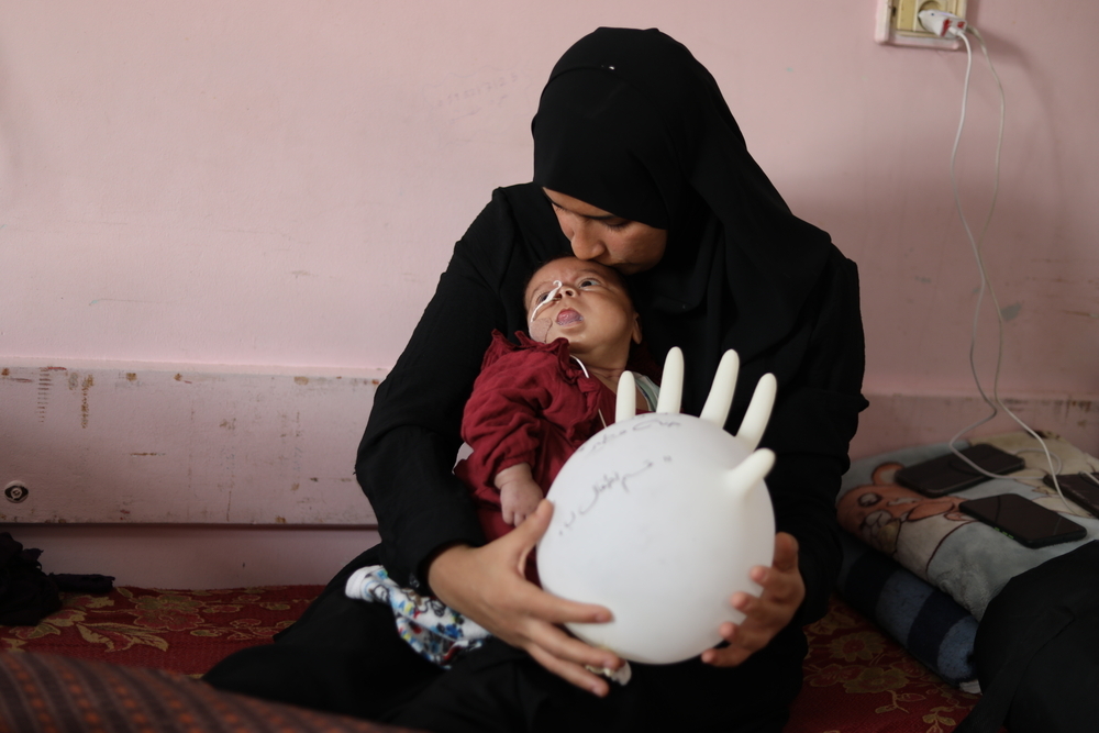 Janna Mtair, âgée de trois mois, sur les genoux de sa mère, Reem Ahmad, à l’hôpital Nasser, après être née avec le syndrome de Beckwith-Wiedemann. Gaza, Palestine. Novembre, 2025 © Nour Alsaqqa/ MSF
