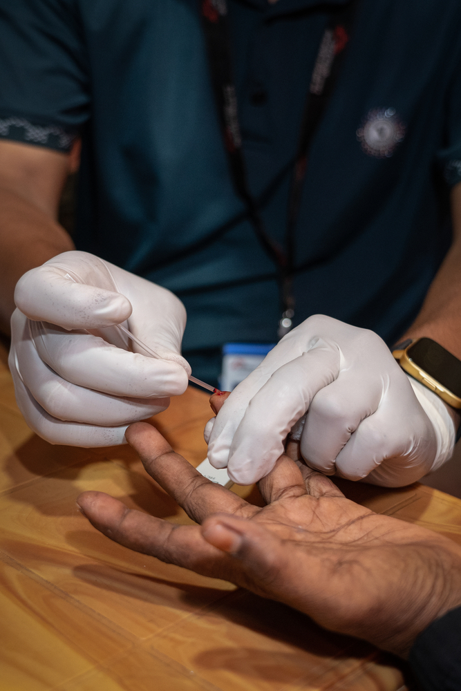 Le personnel de MSF prélève un échantillon de sang sur un patient pour effectuer un test de diagnostic rapide (TDR) de l'hépatite C dans la salle de consultation de l'hépatite C de l'hôpital sur la colline d'Ukhiya, à Cox's Bazar, au Bangladesh.