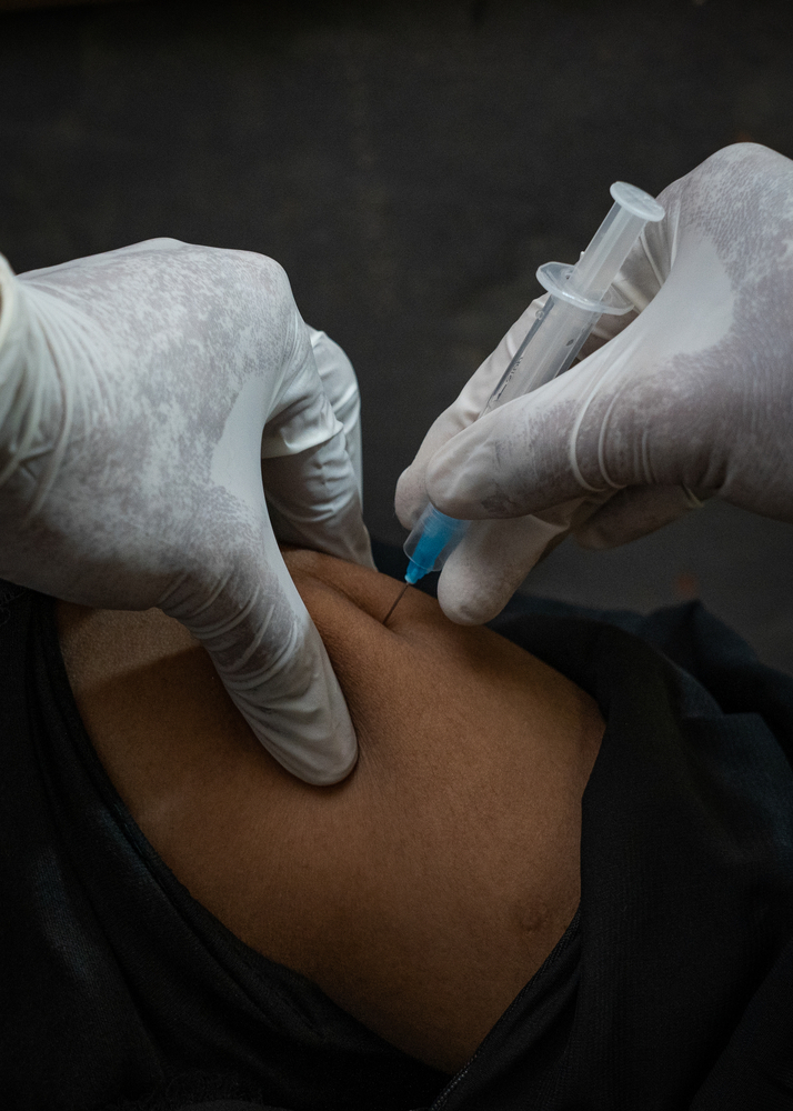 Le personnel de MSF administre un vaccin à un patient au service ambulatoire de l'hôpital MSF sur la colline.
